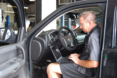 Circle D Technician Conducting Transmission Diagnostics in the Front Seat of Vehicle